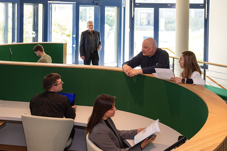 DVGW Berufliche Bildung Personen tauschen sich am Eingang aus DVGW Berufliche Bildung Personen tauschen sich am Eingang aus